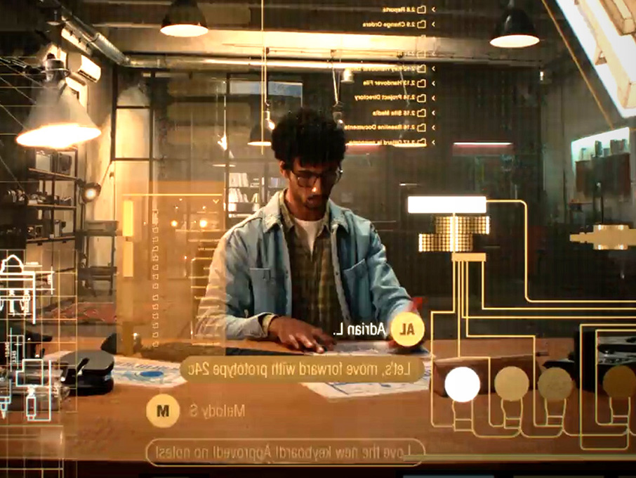 Person working at a desk with digital interface overlays and connected system diagrams.